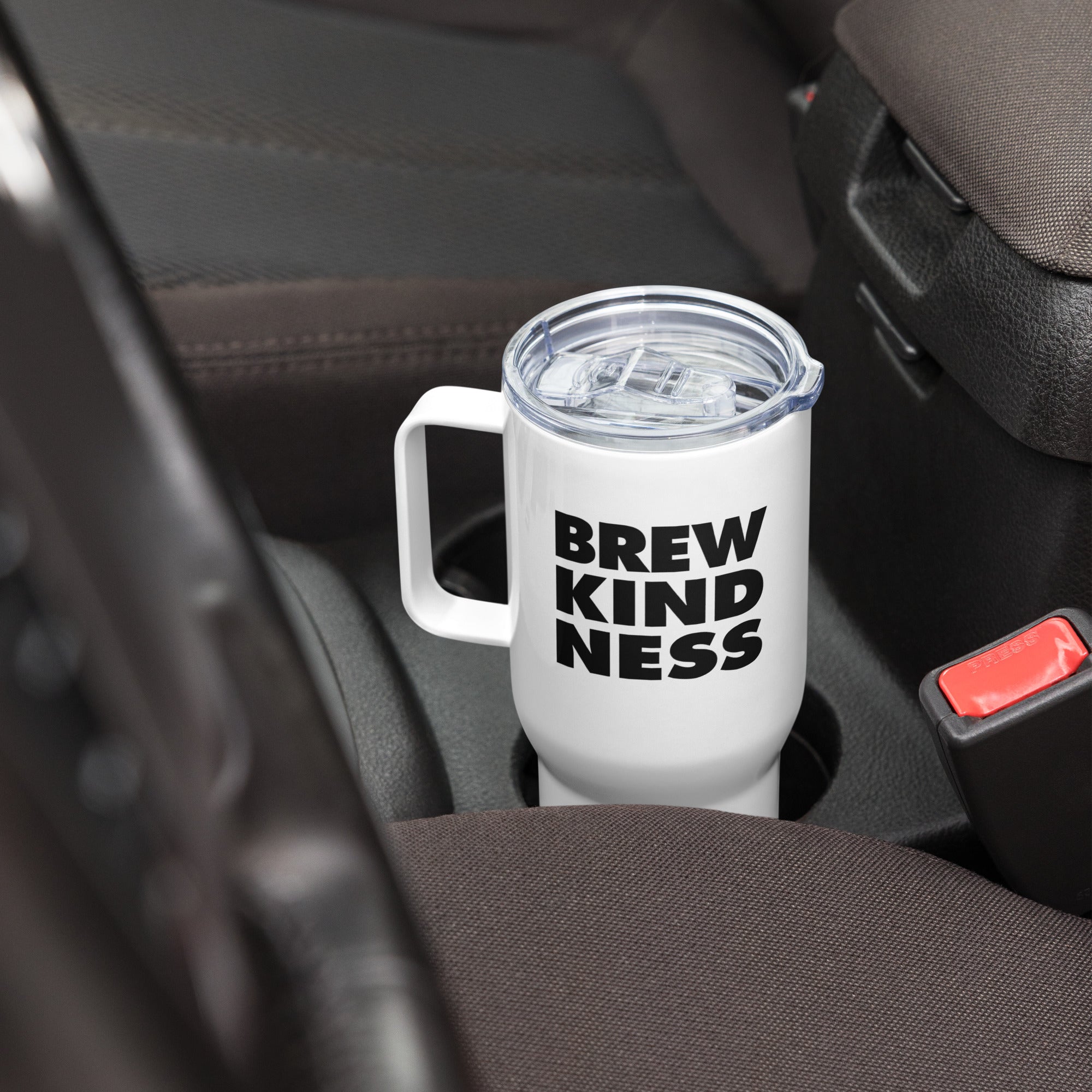 Elevated travel mug with "Brew Kindness" text design sitting in a car cup holder 